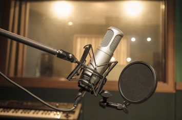 A microphone in a professional recording studio sits idle as Be On Air explains proper microphone set up and usage
