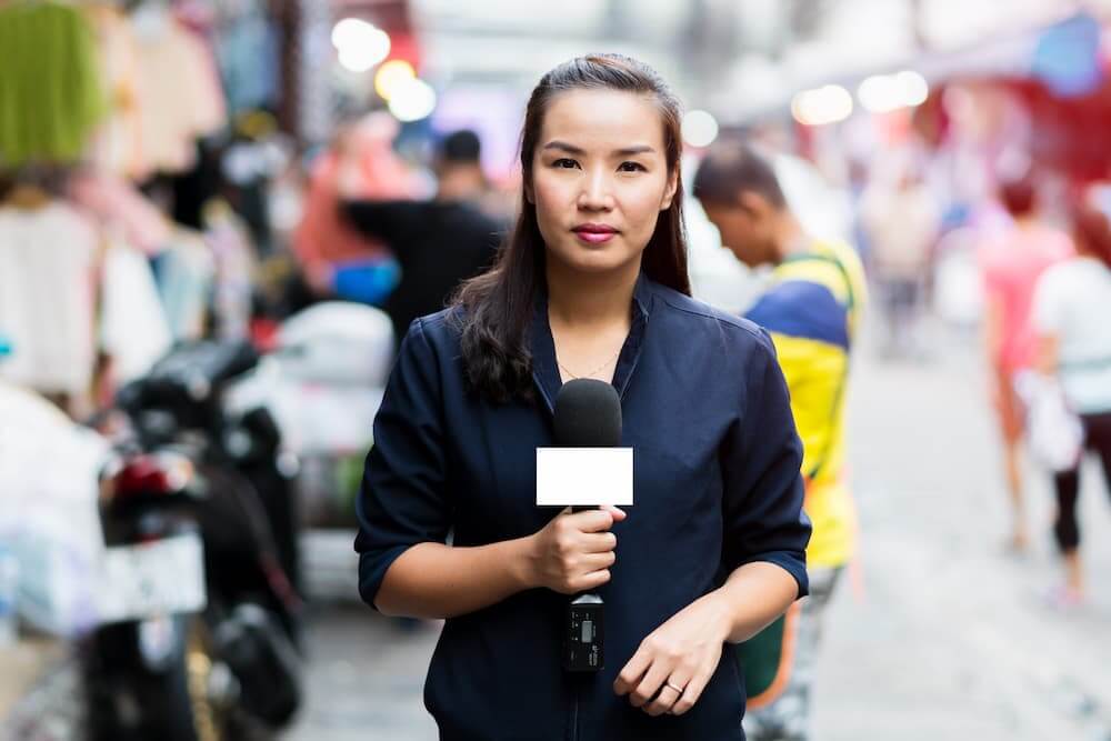 Young asian woman reporter live on the streets
