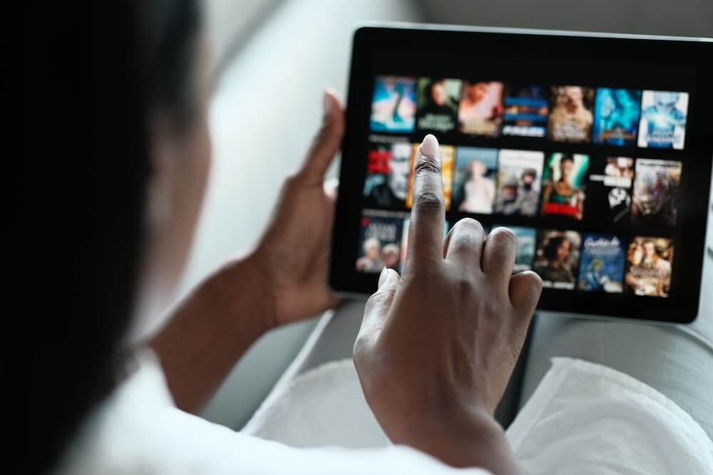 Person clicking through movies and shows in an ipad