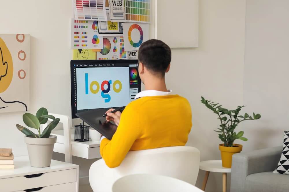Young graphic designer sitting in front of a computer working in photoshop