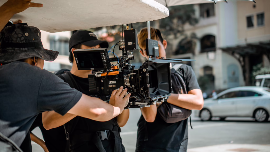 Camera crew operating a cinema camera on a city street during an outdoor shoot